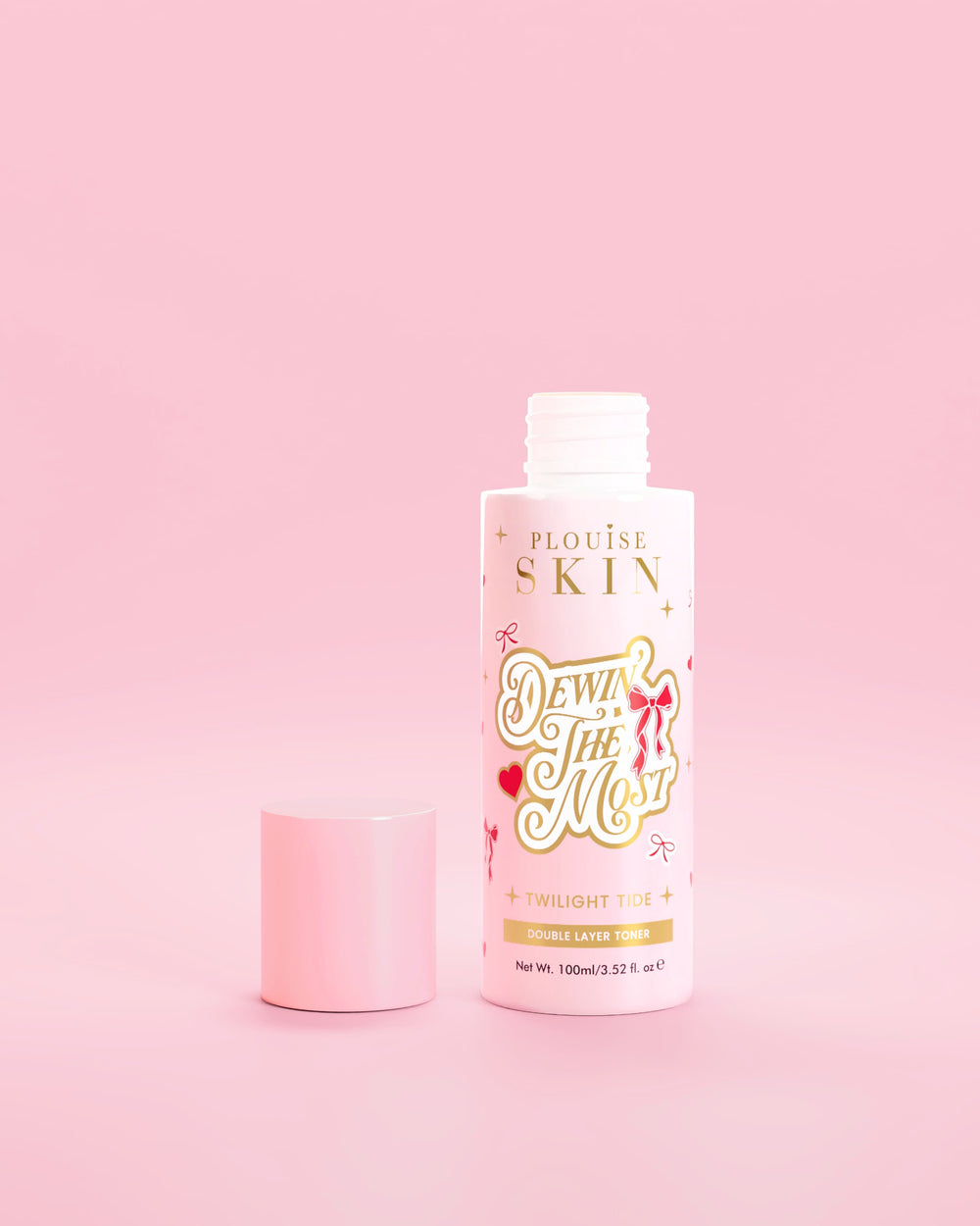 Flacone rosa di P.Louise Dewin The MOst Double Layer Toner con disegni di fiocchi rossi su sfondo rosa