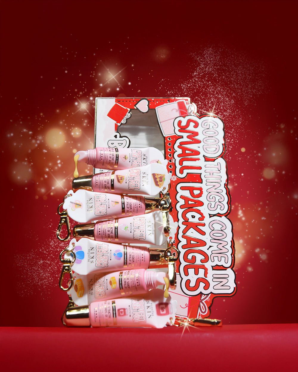 Set regalo di mini balsamo per labbra "All Good Things Come In Small Packages" su sfondo rosso