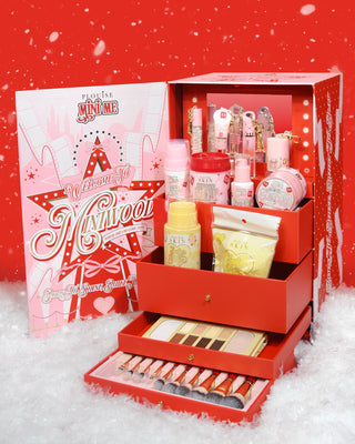 Red P.Louise Miniwood Christmas Vanity Gift Set with open drawers showing a new Christmas collection of products with lights around a mirror inside the box against a red background surrounded by snow