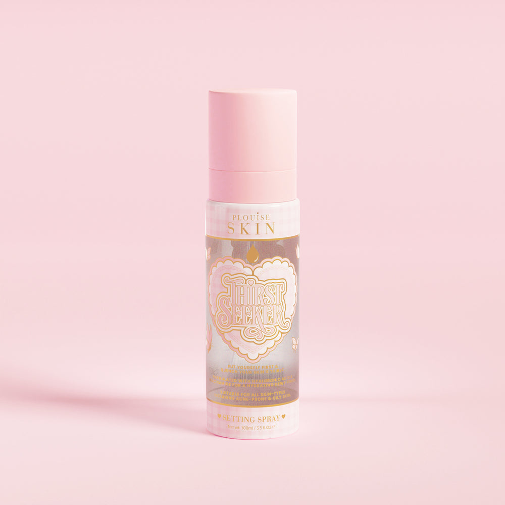 Un flacone spray rosa etichettato "P.Louise SKIN" con la raffigurazione di un cuore e alcuni elementi floreali, contenente uno spray fissante idratante.