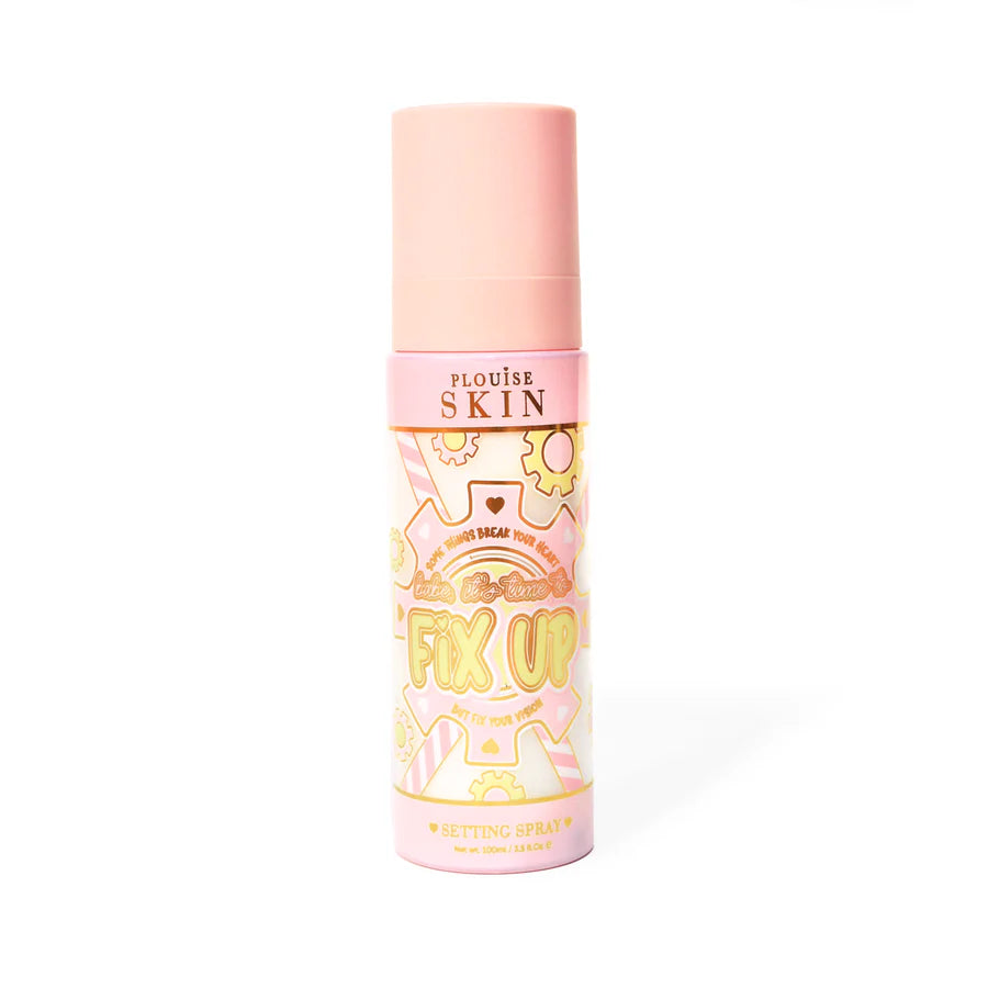 Flacone rosa di spray fissante opacizzante P. Louise Fix Up con un disegno di ingranaggi rosa e gialli sul flacone su uno sfondo bianco