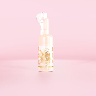 A bottle on the P.Louise In Love With Me foaming face wash in coconut cake scent against a pink background