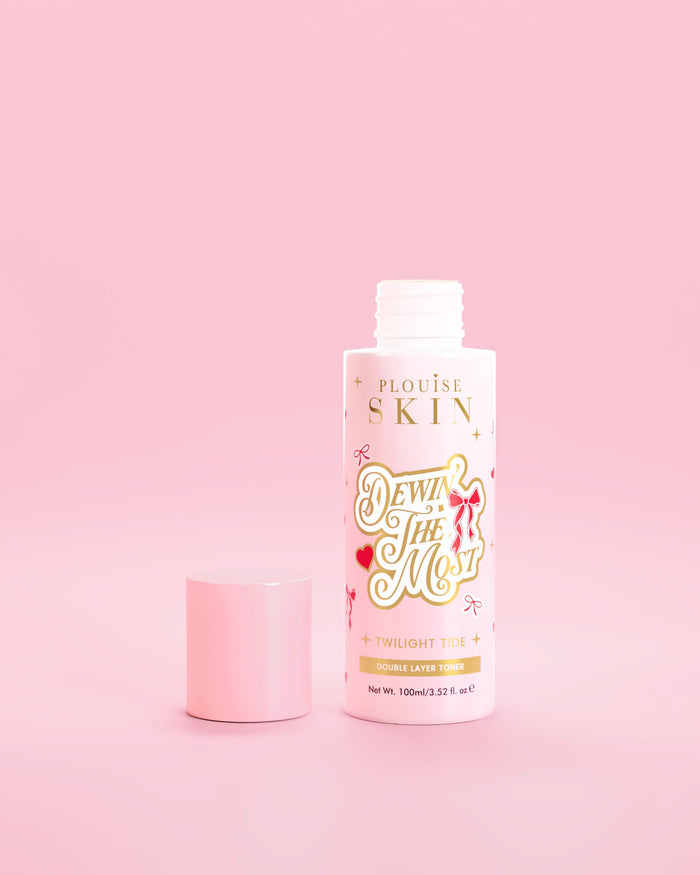 Flacone rosa di P.Louise Dewin The MOst Double Layer Toner con disegni di fiocchi rossi su sfondo rosa 