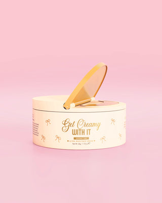 A small tub of the P.Louise Get Creamy With It ultra rich face cream in coconut cake scent against a pink background