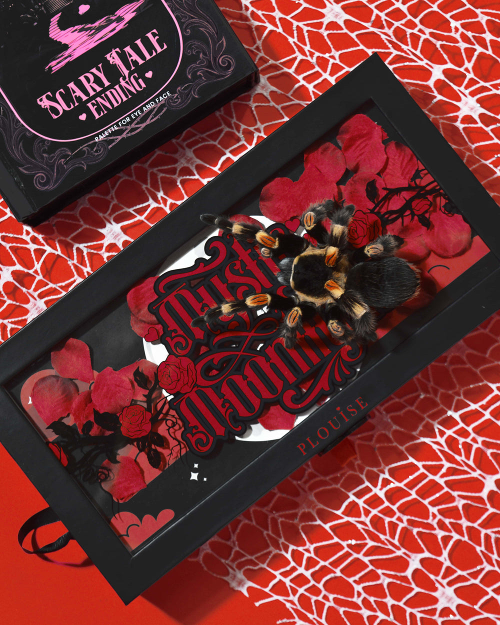 P.Louise Mystic Moonlight Halloween Eyeshadow Palette scatola ricoperta di petali di rosa rossa e una tarantola su uno sfondo di ragnatela rossa