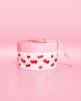 Contenitore rosa con disegno di ciliegie su sfondo rosa