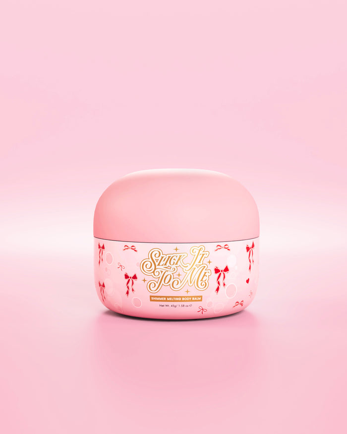 Vaschetta rosa di balsamo per il corpo fondente e scintillante SLick It To Me con elementi decorativi a forma di fiocco rosso su sfondo rosa