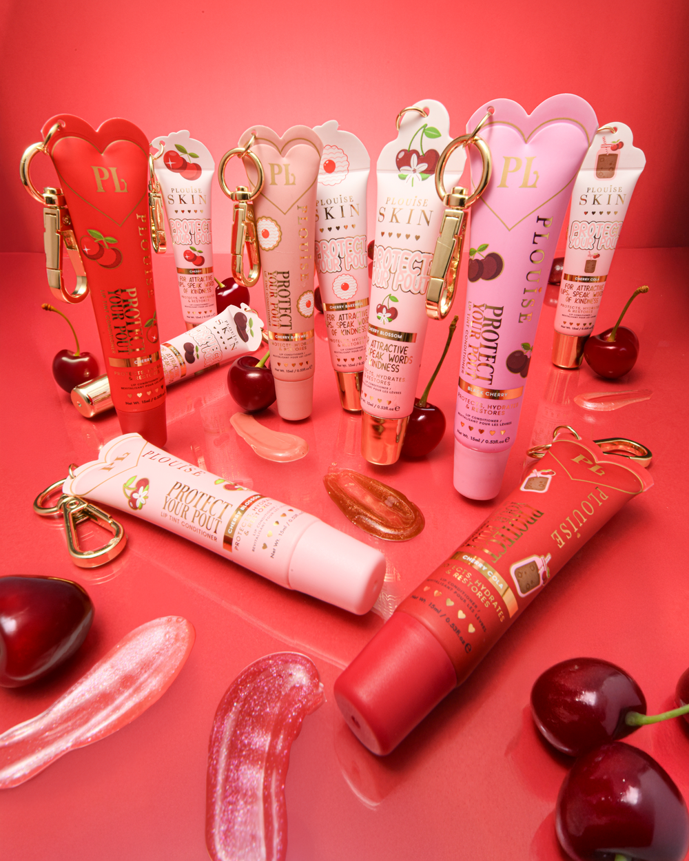 Collezione di ciliegie rosa e rosse che proteggono i tuoi balsami per labbra con campioni e ciliegie posizionate attorno ad essi su uno sfondo rosso
