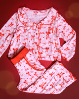 Set di pigiami natalizi per bambini a righe rosa e bianche con disegni di fiocchi rossi su uno sfondo rosso