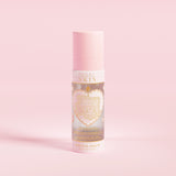 Un flacone spray rosa etichettato "P.Louise SKIN" con la raffigurazione di un cuore e alcuni elementi floreali, contenente uno spray fissante idratante.