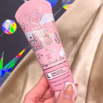 Una persona che tiene in mano un tubetto di P.Louise Silk Slumber Poreless Primer con uno sfondo rosa e dettagli del prodotto cosmetico.