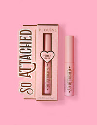 La confezione del prodotto P.Louise So attached Lash Glue e il tubo della colla stessa, posizionati su uno sfondo rosa.