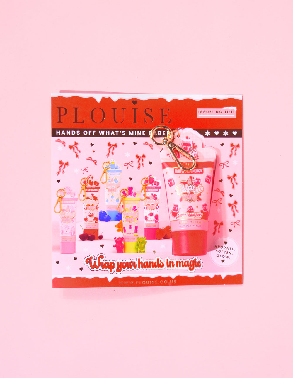 Rivista natalizia di P.Louise con un mini portachiavi con crema per le mani al mirtillo rosso attaccato alla rivista con un design festivo rosso e rosa