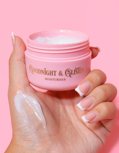 Una mano che tiene un barattolo rosa di P.Louise Goodnight & Glisten Gel Moisturizer con un po' di crema idratante visibile su .e
